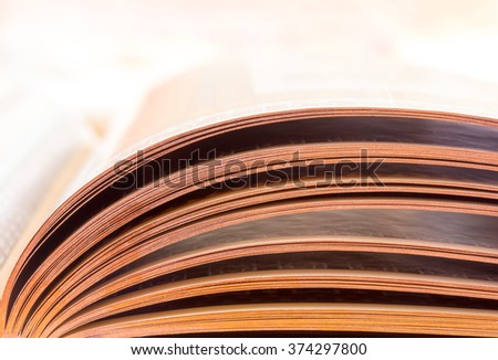 the leaves of an open book lit by daylight, close-up