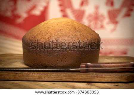 home-made cake with sunflower seeds from a bread machine on the kitchen table with a board and knife