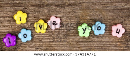 i love message on beads on wooden background 