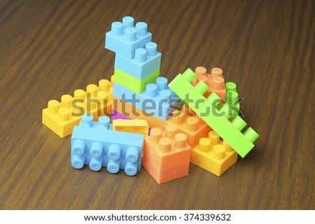 Plastic toy blocks on wooden background
