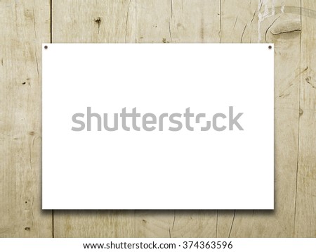 Close-up of one hanged paper frame with nails on light brown wooden boards background
