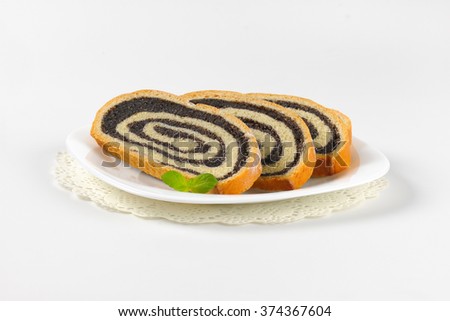 sliced poppy seed roll on white plate