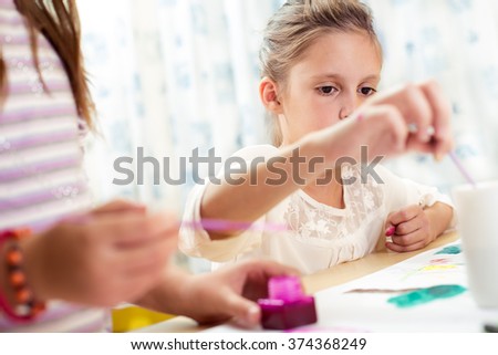Two little girls drawing pictures