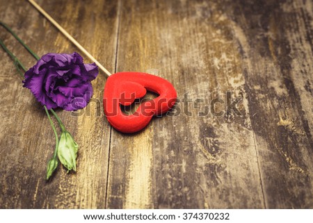 Red hearts decoration with eustoma flowers on old wooden texture background, valentines day card concept. Old wooden table with texture. 