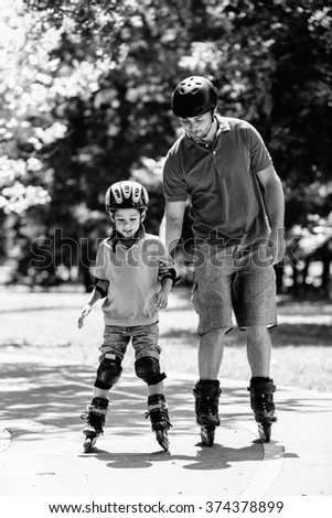 Father and son roller skating together. Black and white