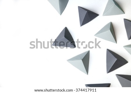Creative background with black and gray origami tetrahedrons with free copy space on the left side. Great for using in web.