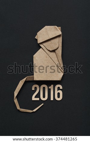 Folded paper origami monkey on black background. 2016 lettering vertical postcard template.