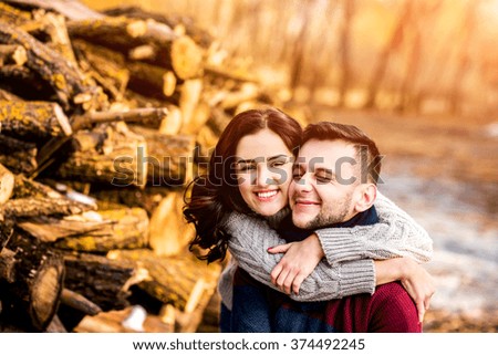 Pretty young couple outdoor near wooden stock