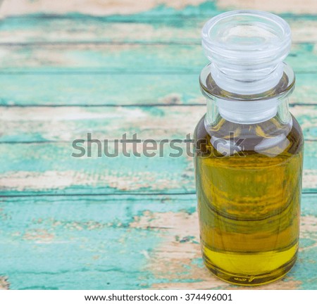 Avocado oil in glass vial over wooden background