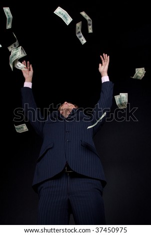 Buisnessman and falling down money. On black background.