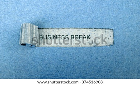   Torn blue paper on dull blue surface with "business break"                             
