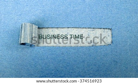   Torn blue paper on dull blue surface with "business time"                             