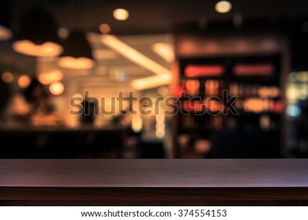 Empty top of wooden table or counter on cafeteria, bar, coffee shop background. For product display Royalty-Free Stock Photo #374554153