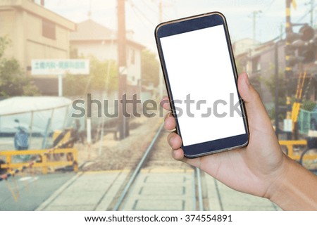 Man hand holding mobile smart phone , tablet,cellphone over Blur of railway track blurred backgrond with perspective and gradient,grunge grainy vintage photo