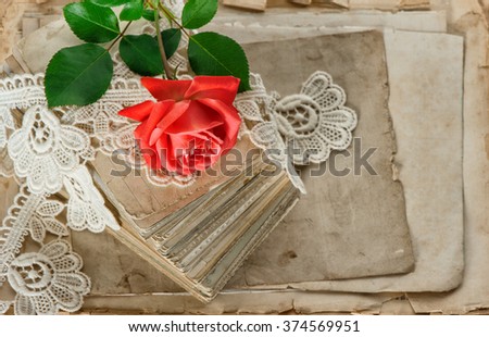 Old love letters and red rose flower closeup. Aged papers and lace