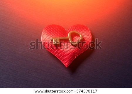 Red heart with the key on a metal surface