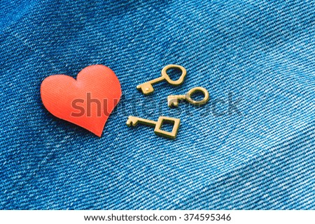 Red heart with three keys on jeans background