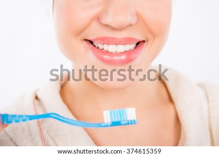Closeup photo of young girl smiling with perfect  white teeth and toothbrush