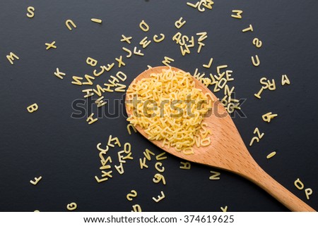 alphabet pasta in wooden spoon Royalty-Free Stock Photo #374619625