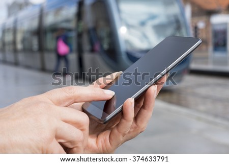 Female using her cell phone on platform station tramway