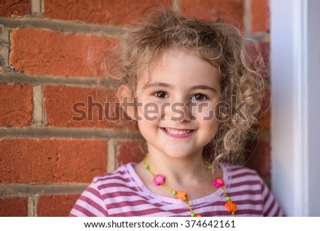 Young girl, child, outdoors, smiling.