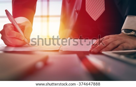 Close up businessman signing documents.