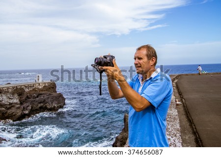 A man making a photo near ocean. Background