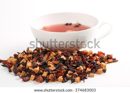 Still life, aromatic dry tea with fruits and petals, close up with a cup of tea on white background, selective focus 