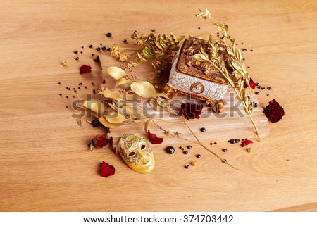 Beautiful creative still life. Golden twigs box and theatrical mask.