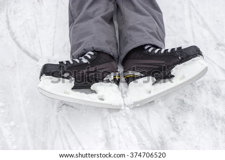 legs in hockey skates on ice fallen