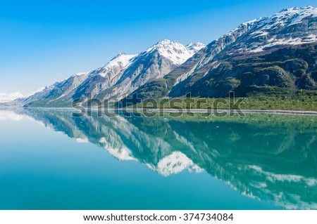 The beauty of North America | Alaska: Picturesque view of the mountains reflecting in still water of Glacier Bay in  Alaska, United States. Royalty-Free Stock Photo #374734084