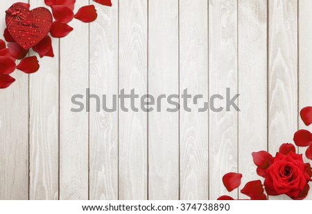 Love background scene with free space for text. Petals, rose, gift heart on wooden background.