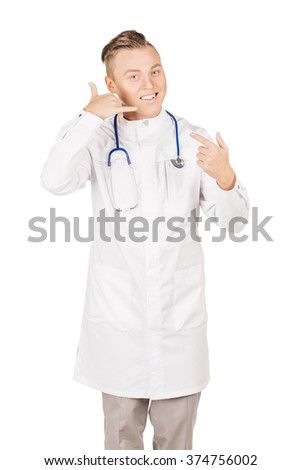 Young  male doctor in white coat and stethoscope showing "call me" gesture. People and medicine concept. Image isolated on a white background.
