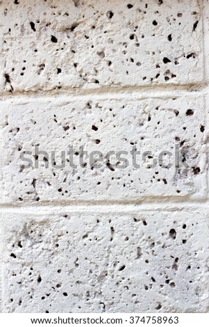 Weathered texture of stained old dark white and gray brick wall background, grungy rusty blocks of light stone-work technology, colorful horizontal architecture
