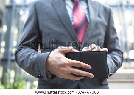 Business man taking bills out of wallet