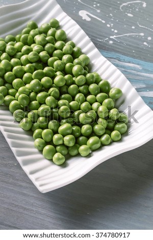 Peeled Green Peas in a white plate on a wooden background, Selective Focus.