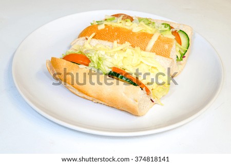 Large cheese and salad bread stick cut and on a plate
