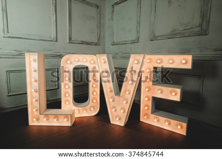 LOVE letter with light bulb in the corner of vintage dark room