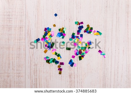 Colorful confetti on wood background