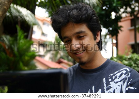 A young man using his laptop outdoors