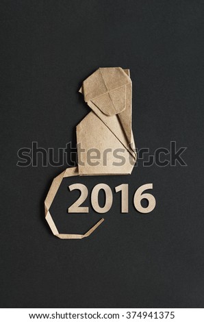 Folded paper origami monkey on black background. 2016 lettering vertical postcard template.