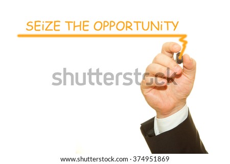 Businessman hand writing Seize the opportunity on a transparent wipe board
