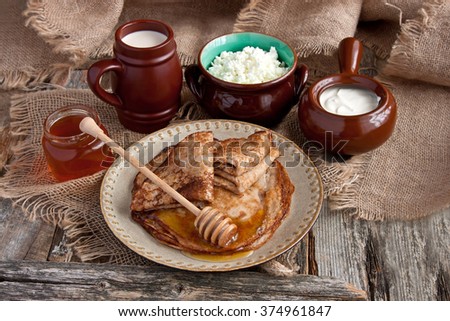 Fresh pancakes, dairy products on wooden table