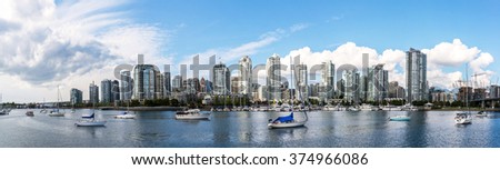 panoramic view of the buildings of vancouver city skyline behind a marina during a sunny day in british columbia in canada