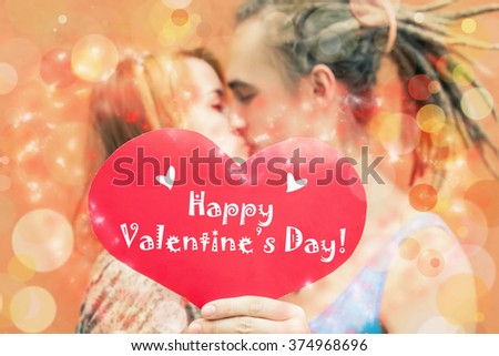 Happy Valentines Day couple holding red heart symbol and kissing, 14th February celebration, Valentine. Love concept.