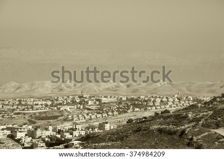 View of Judaean Desert and Maale Adumim town in haze from Mount Scopus in Jerusalem (Israel). Aged photo. Sepia.