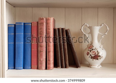 Vintage books on the shelf and a vase