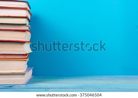 Stack of colorful books, grungy blue background, free copy space