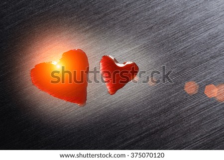 Large and small hearts on a metal surface