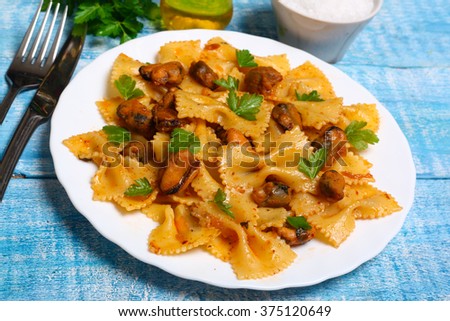 pasta with mussels and parsley on a wooden background